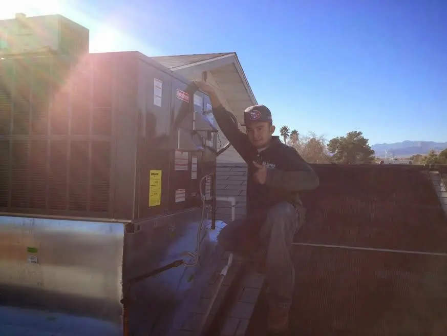 HVAC technician performing AC Tune-Up on a rooftop unit in Ruskin